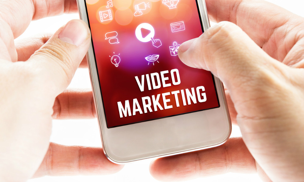 Close up Two hand holding mobile phone with Video marketing word and icons Online Digital Marketing concept