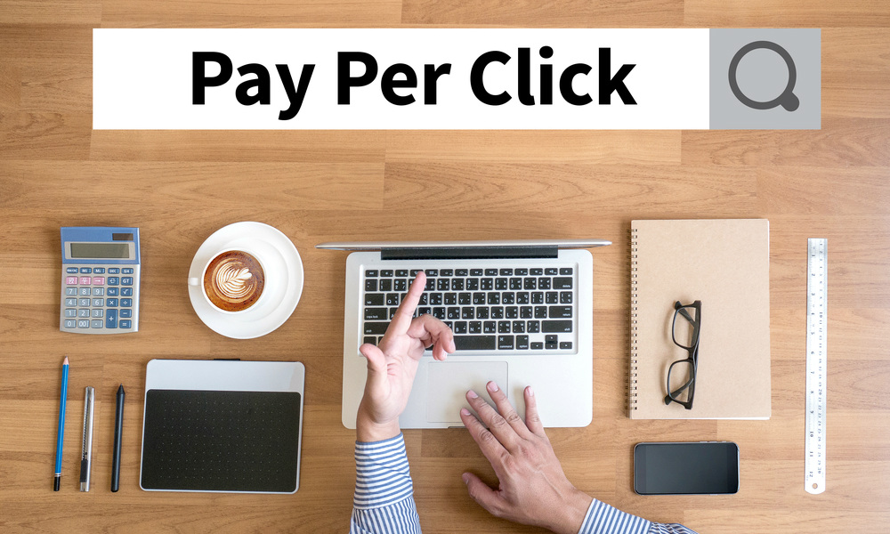 PPC - Pay Per Click concept Businessman working with financial reports and a laptop