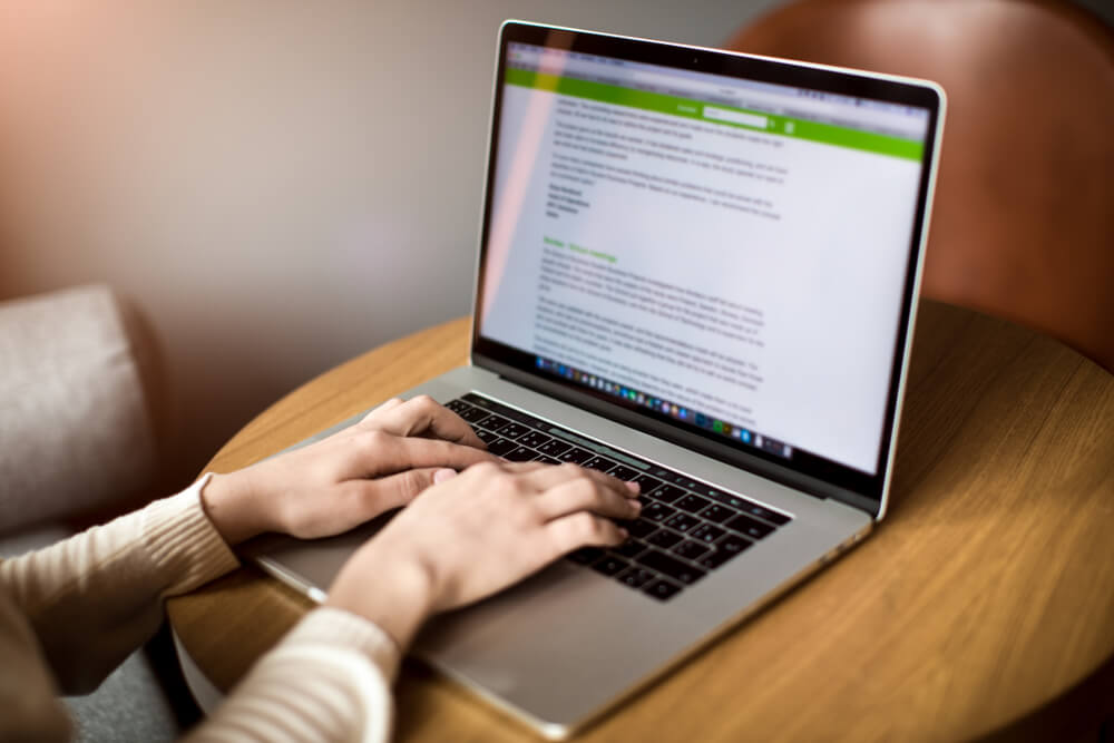 A Content Writer Typing Text on Laptop